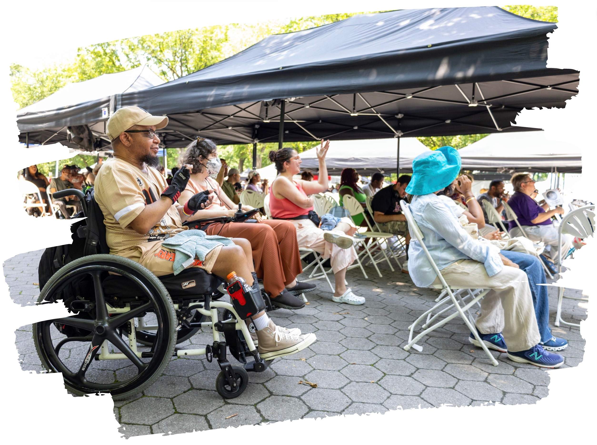 Attendees at a Project Access for All outdoor event in New York City — including wheelchair users and people from many communities — seated together under event tents.