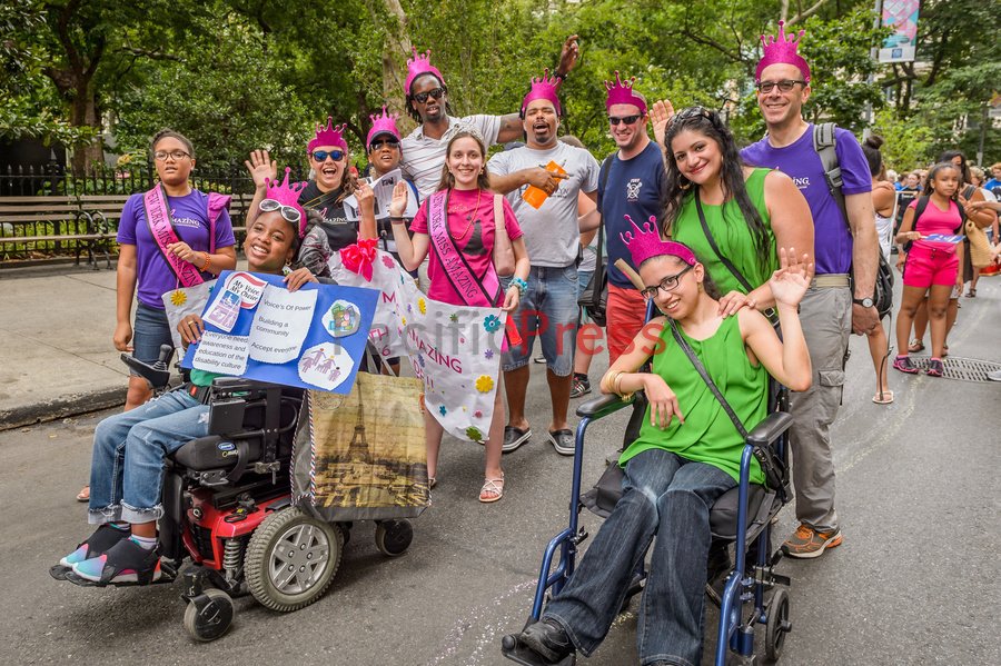 Crowd of parade marchers wearing purple crowns 