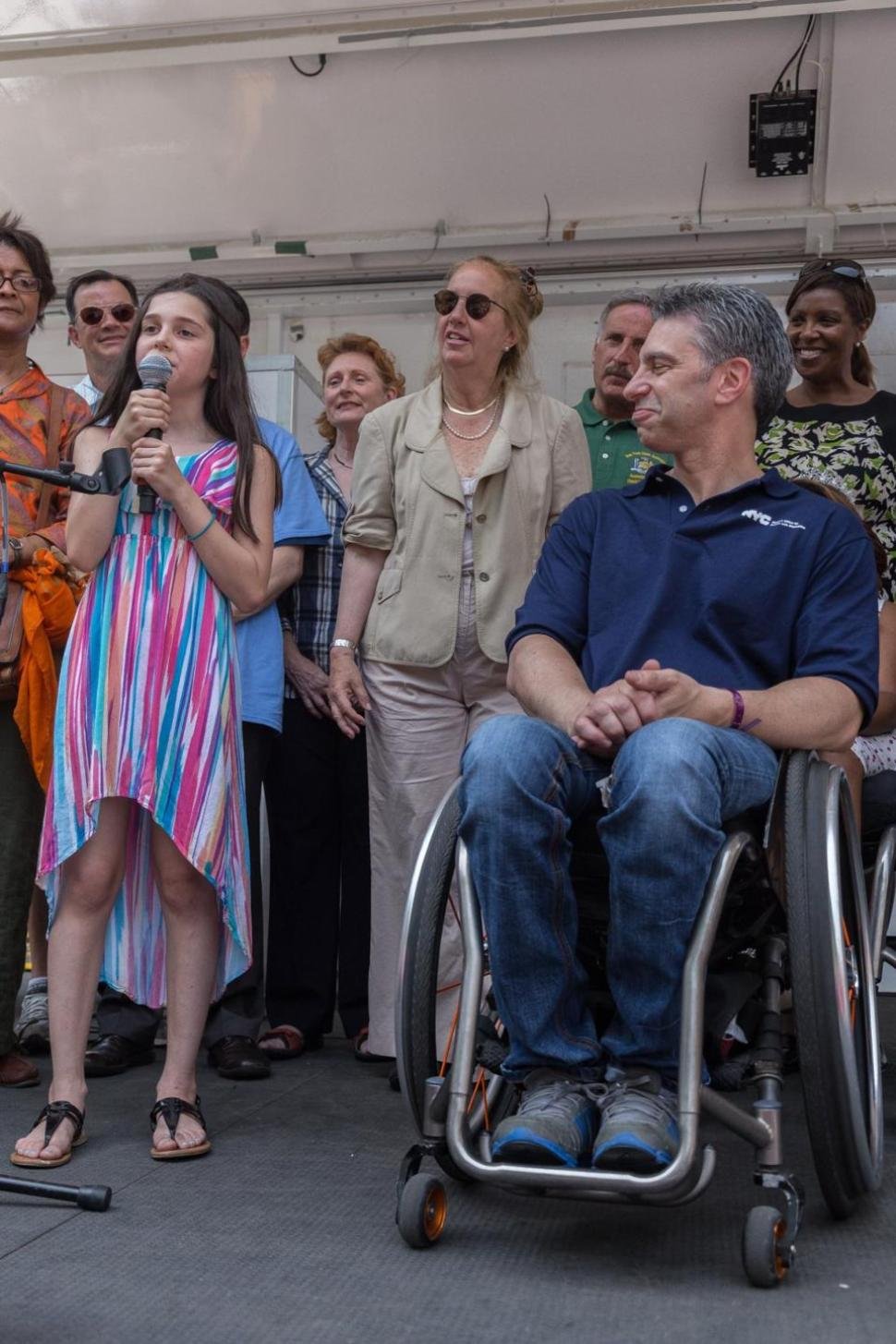 Victor Calise, commissioner of the Mayor's Office for People with Disabilities, next to his daughter Lola Claise who sings a song to kick off the parade