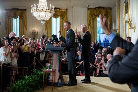 An interpreter signs in the foreground while President Barack Obama, with Vice President Joe Biden, delivers remarks during a reception for the 25th anniversary of the Americans with Disabilities Act (ADA) 