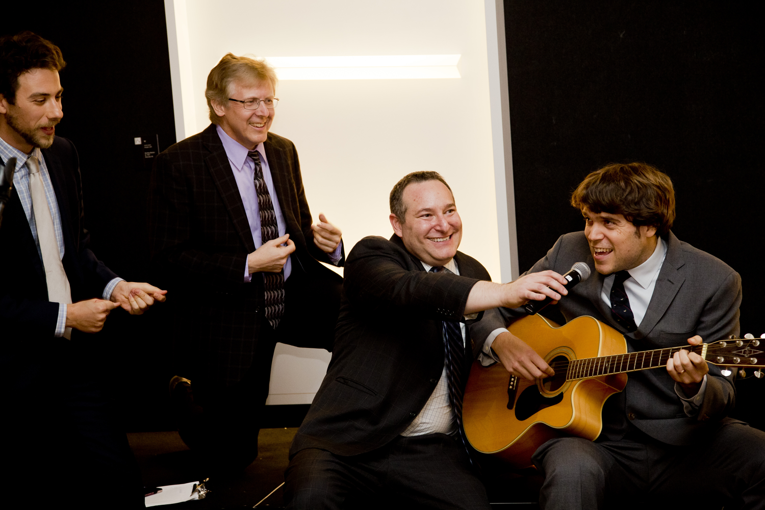 Four men in suits singing