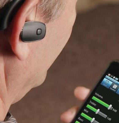 Man with hearing aid and personal amplifier Photo Trendhunter.com