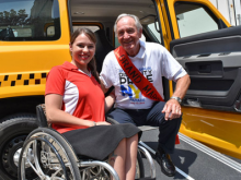 A woman in a wheelchair taking a picture with the Grand Marshal of the parade, Tom Harkin.
