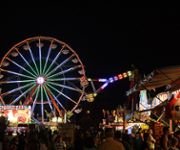 A large crowd of people in front of a carnival ride.