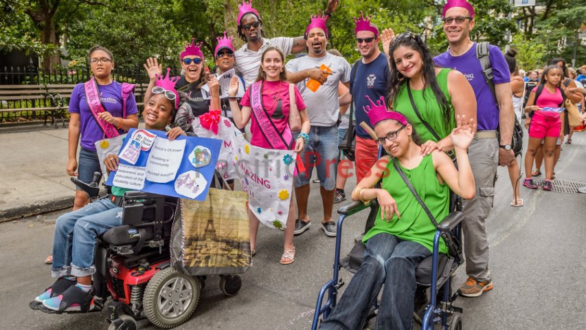 Crowd of parade marchers wearing purple crowns 