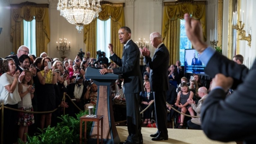 An interpreter signs in the foreground while President Barack Obama, with Vice President Joe Biden, delivers remarks during a reception for the 25th anniversary of the Americans with Disabilities Act (ADA) 